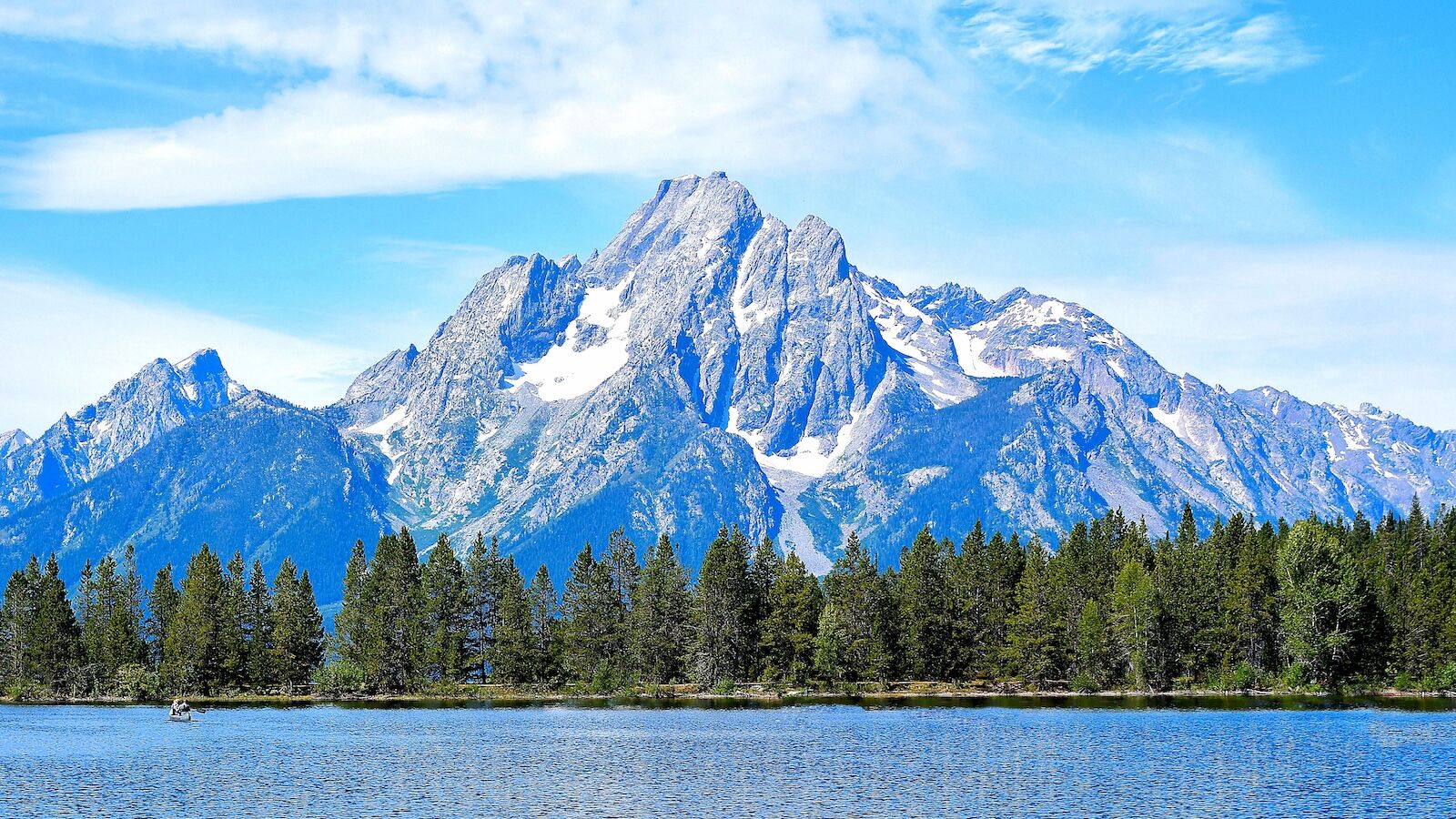 Grand Teton mountains reflected in a lake at a national park resort area