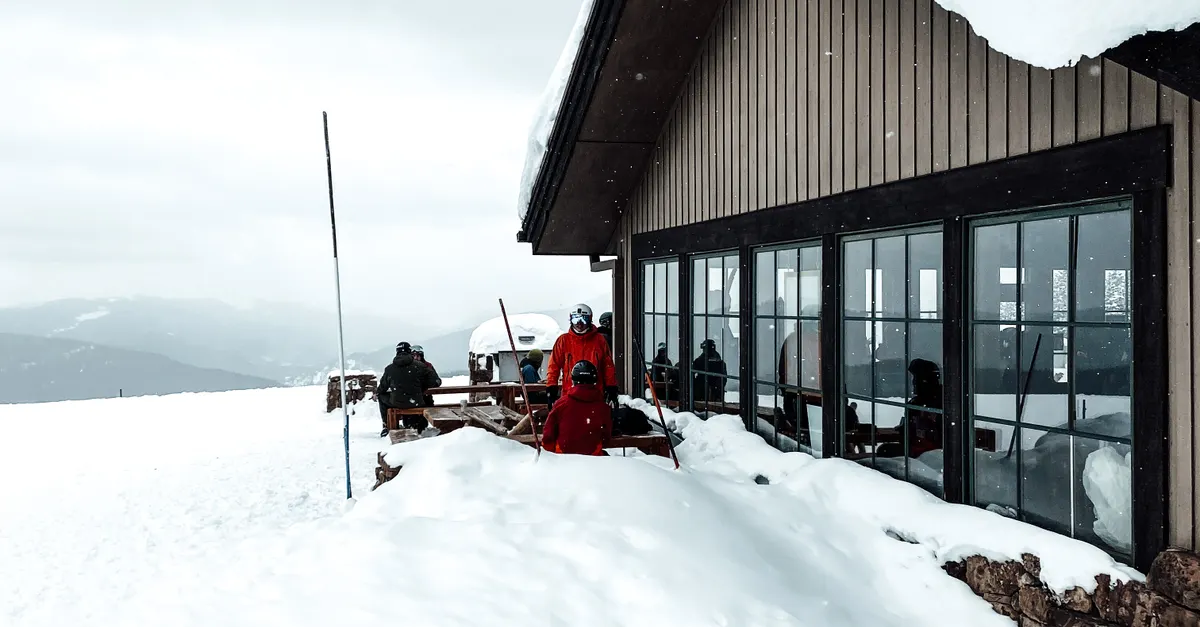 Seasonal workers outside a snow-covered ski lodge